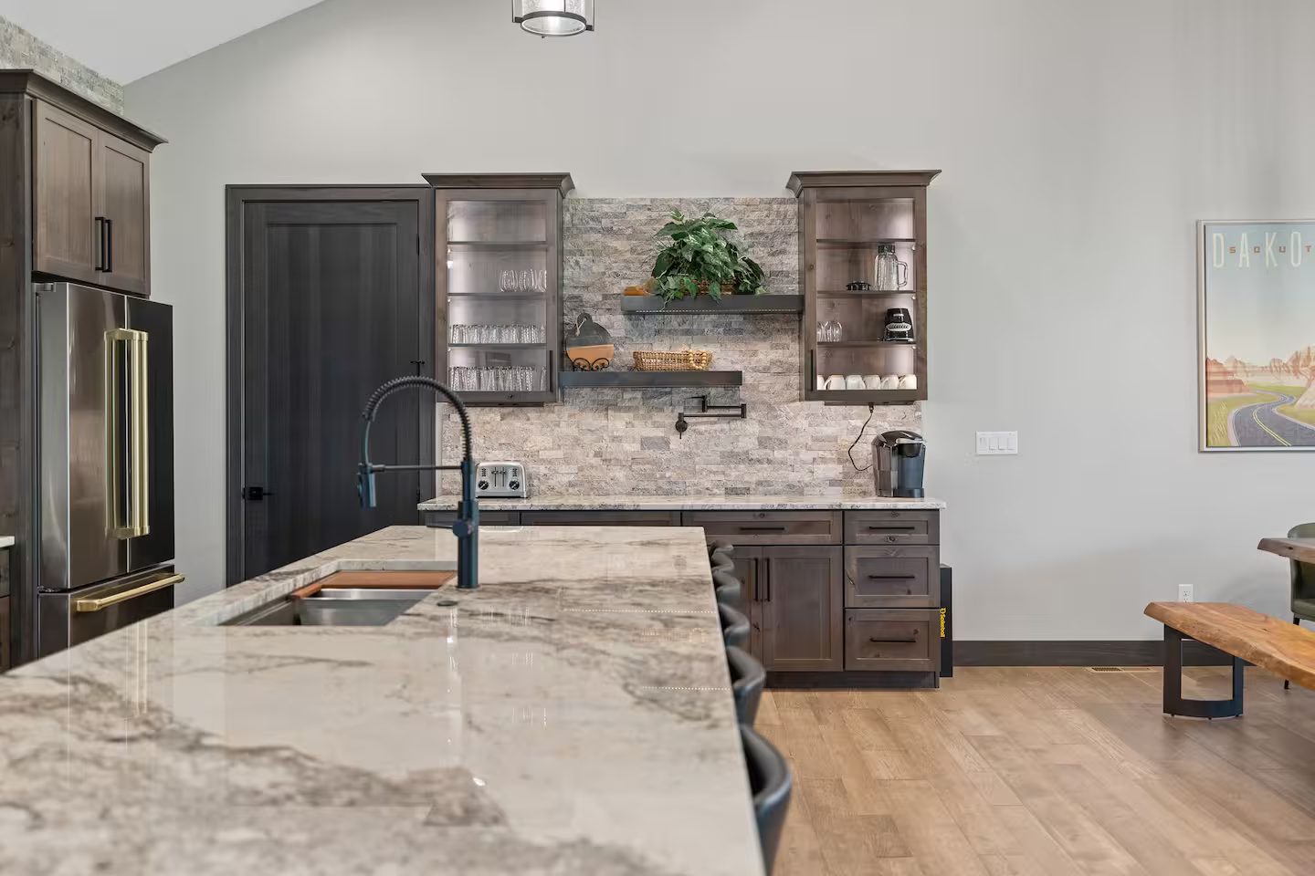 Stone island with a black faucet, looking toward the coffee bar
