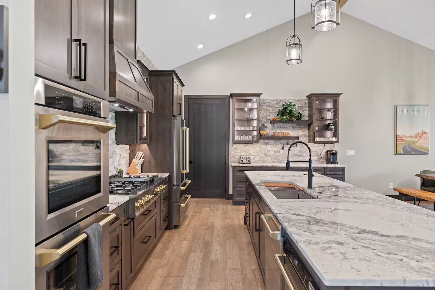 Double wall ovens and the gas rangetop along the stacked-stone wall