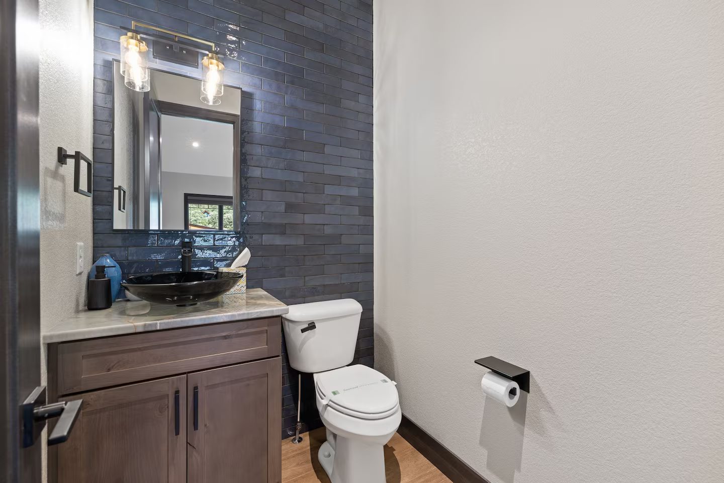 Powder room with navy tile, a black vessel sink and a dark wood vanity
