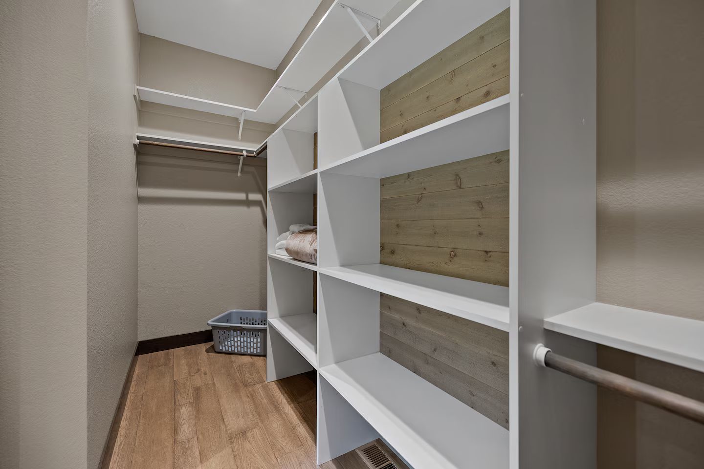 Walk-in closet with white shelving and hanging rods