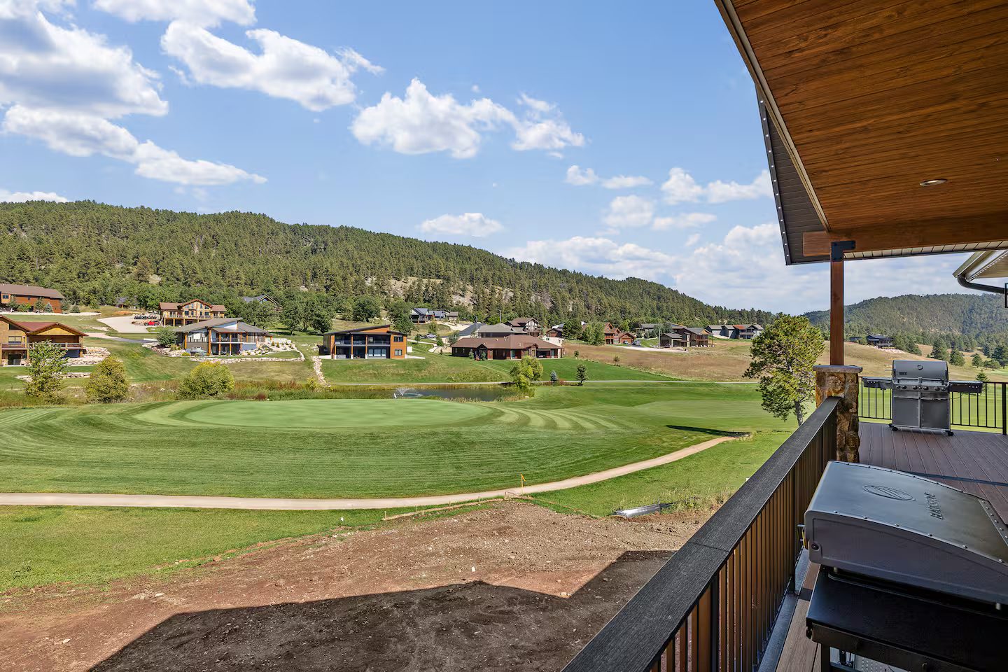 View from the deck over the green and the golf course to the forested hills