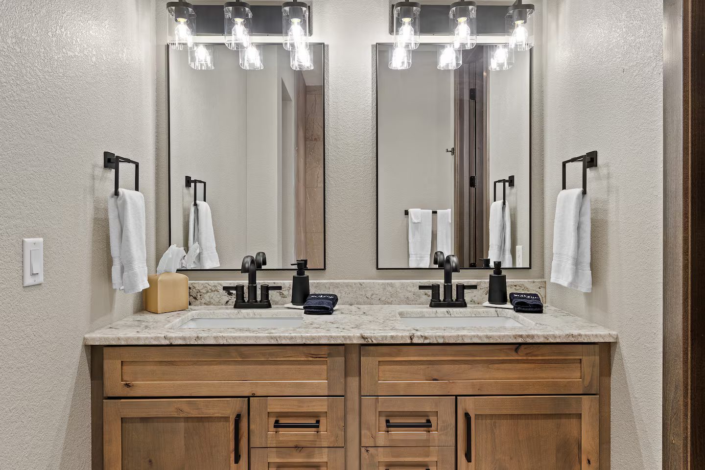 Bathroom with a double vanity, two mirrors and black fixtures
