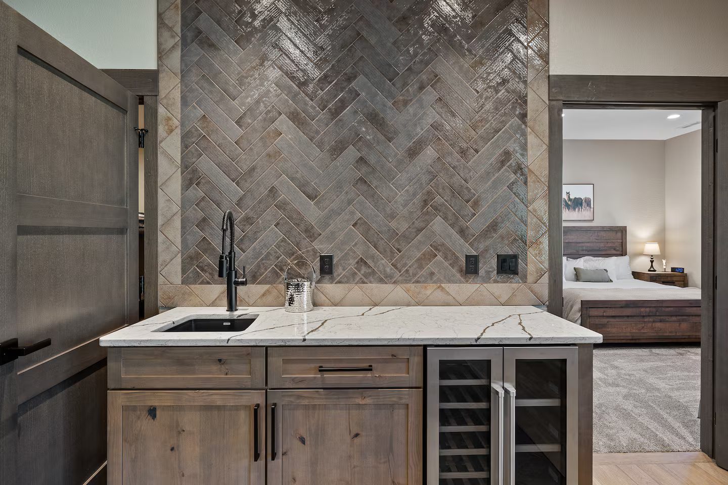 Wet bar with a herringbone tile wall, a small sink and a wine fridge